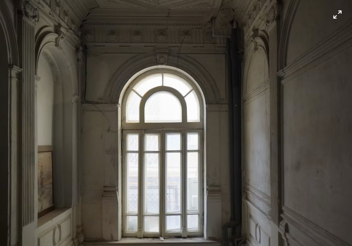 Interior histórico bañado en luz natural, muros con textura